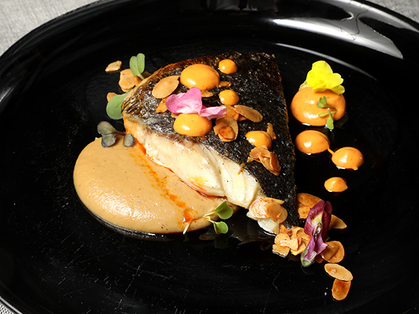 Corvina a la plancha con cremoso de coliflor tostada y almendra Marcona